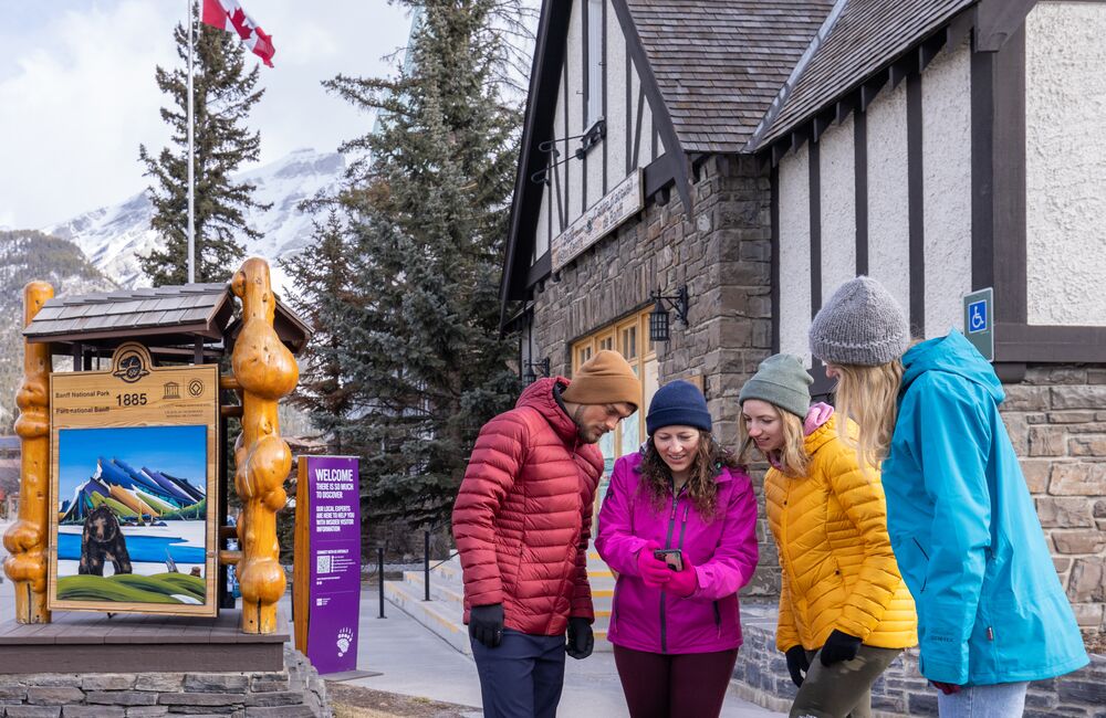 Group of friends discussing their plans for the day in front of the Visitor Centre in Banff.